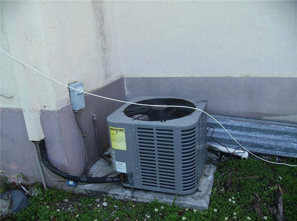 Exterior HVAC condenser unit mounted on a concrete pad
