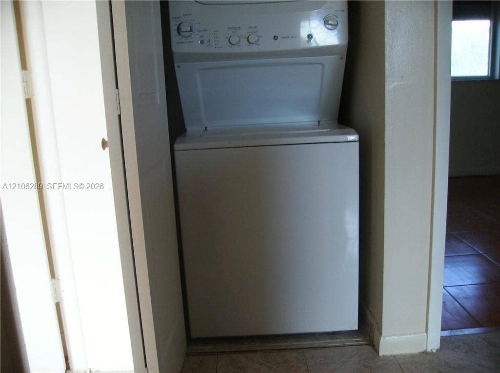 Stacked white laundry unit housed within a dedicated closet