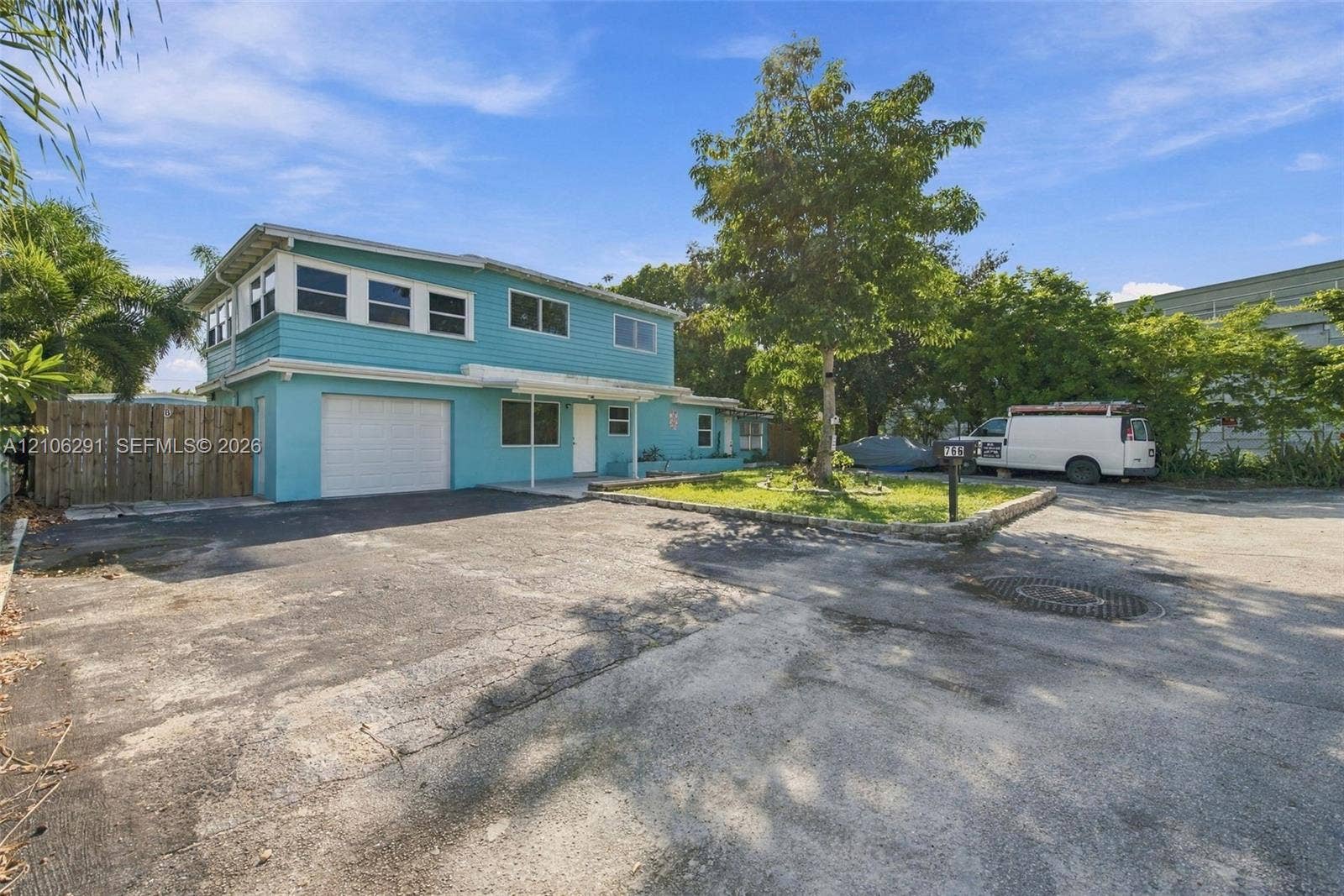Two-story residence featuring horizontal lap siding, an integrated single-car garage, and an expansive paved driveway