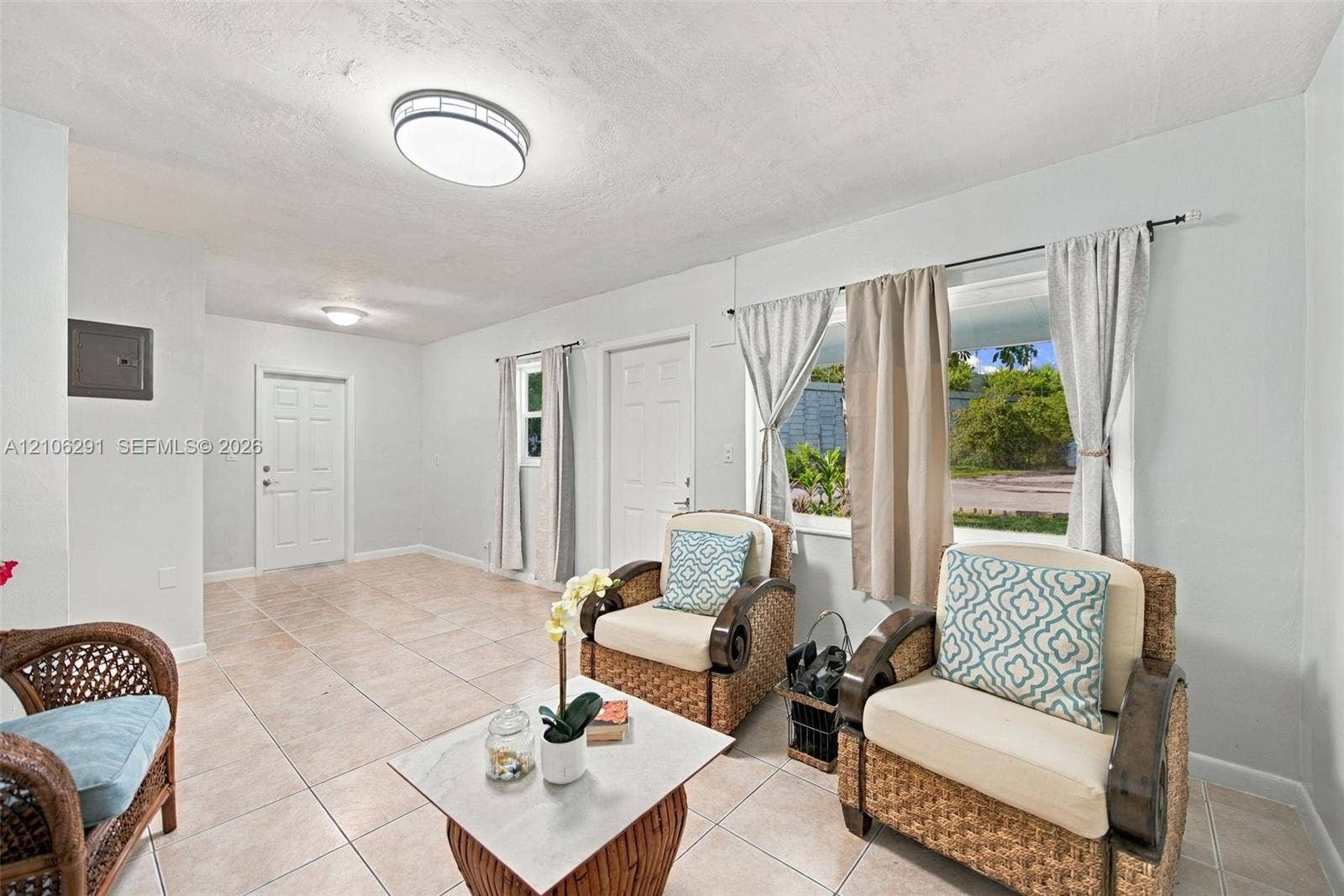 Neutral-toned ceramic tile flooring, crisp white interior paint, multi-pane window, and dual flush-mounted ceiling light fixtures