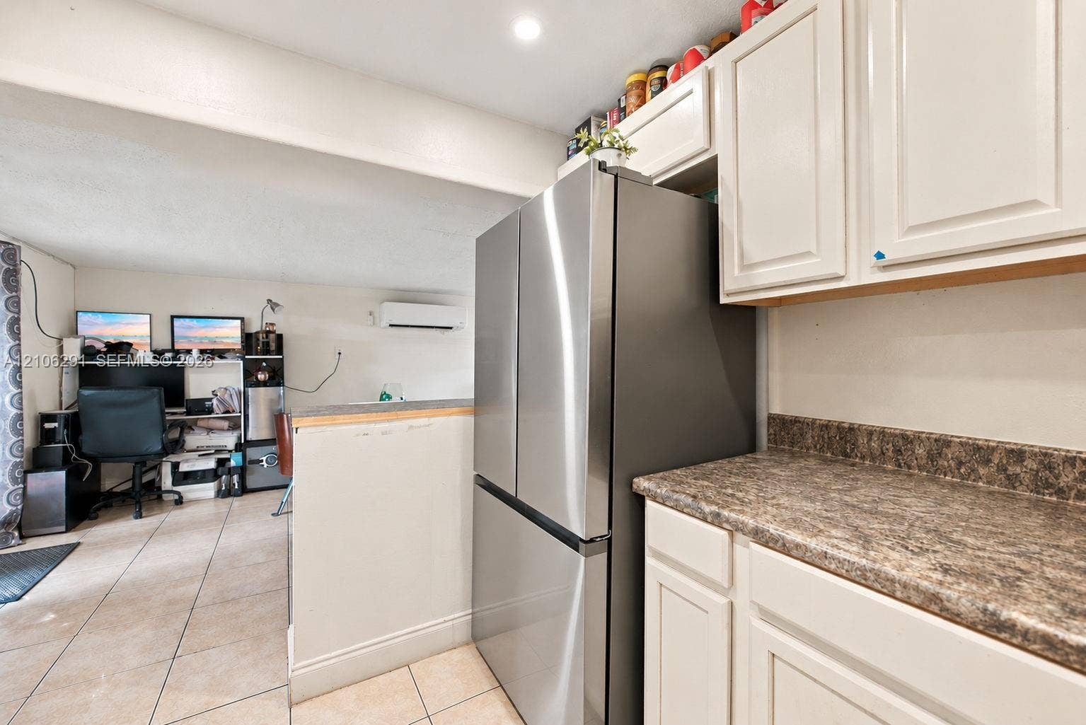 Kitchen featuring white cabinetry, stone-finish countertops, stainless steel refrigerator, and tiled flooring