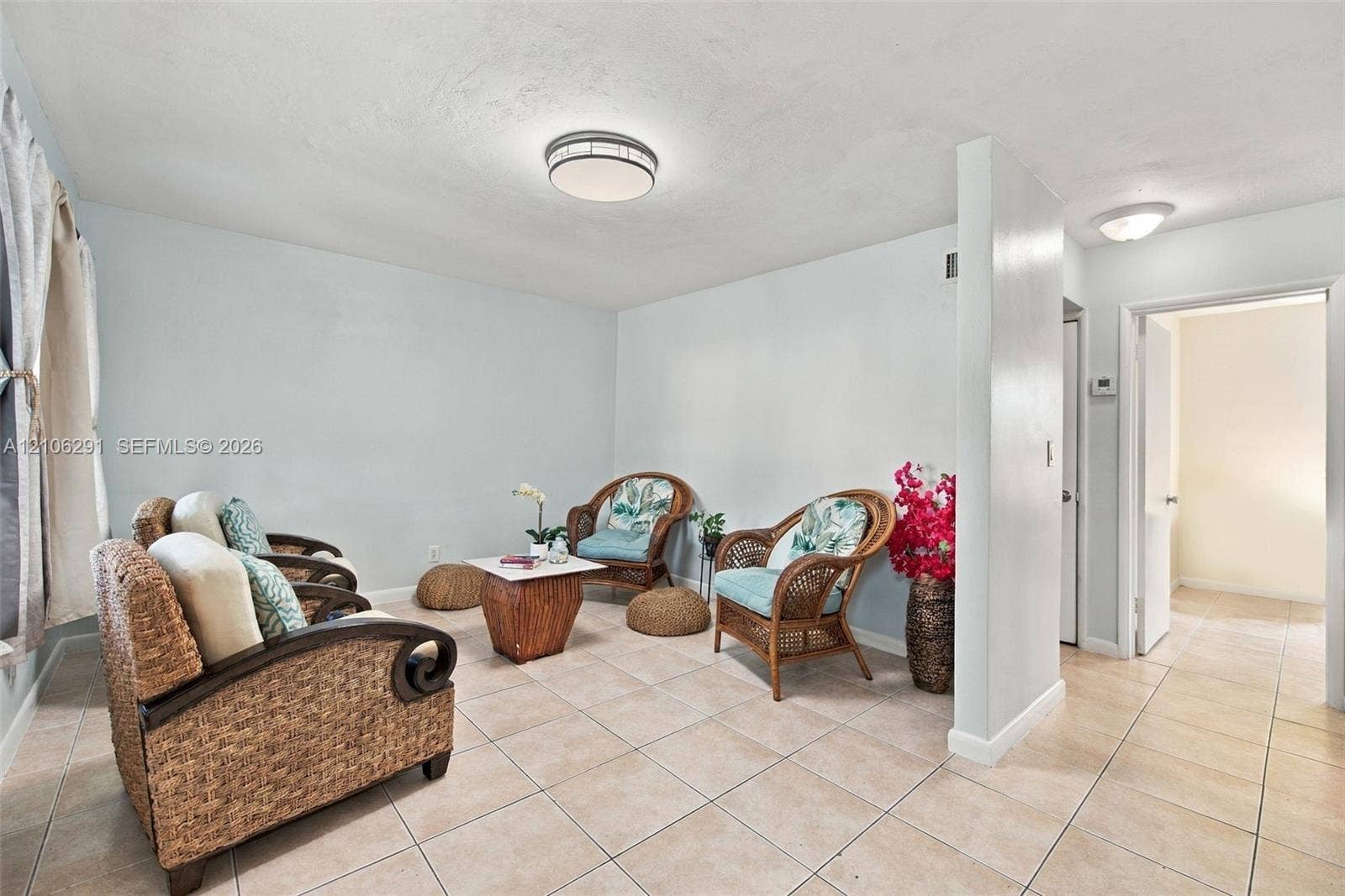 Neutral ceramic tile flooring, rounded flush-mount ceiling lighting fixtures, and solid-core interior doors