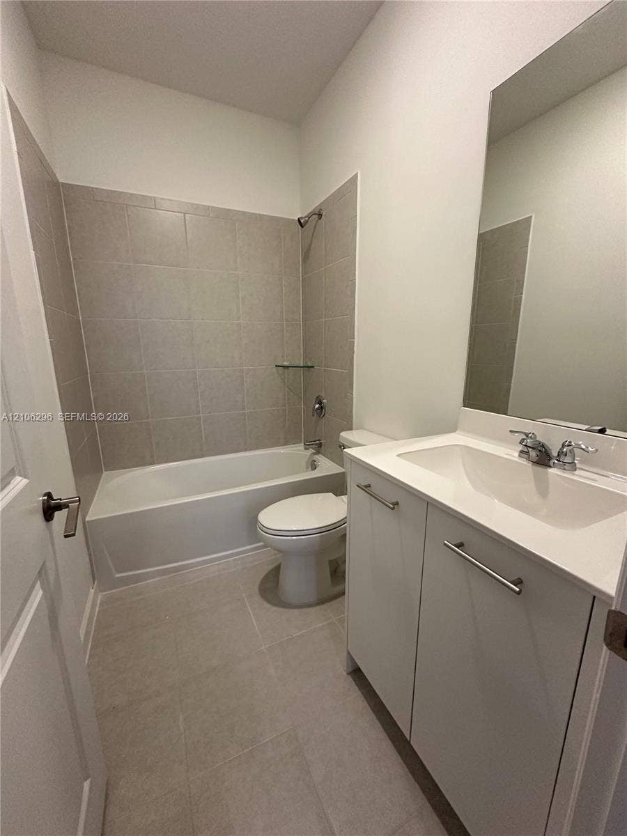 12103 NW 24th Place, #12103, Miami, Miami, FL 33167 Full bathroom featuring a white vanity cabinet with a stone-composite countertop, integrated sink, tile flooring, and a bathtub with tile surround