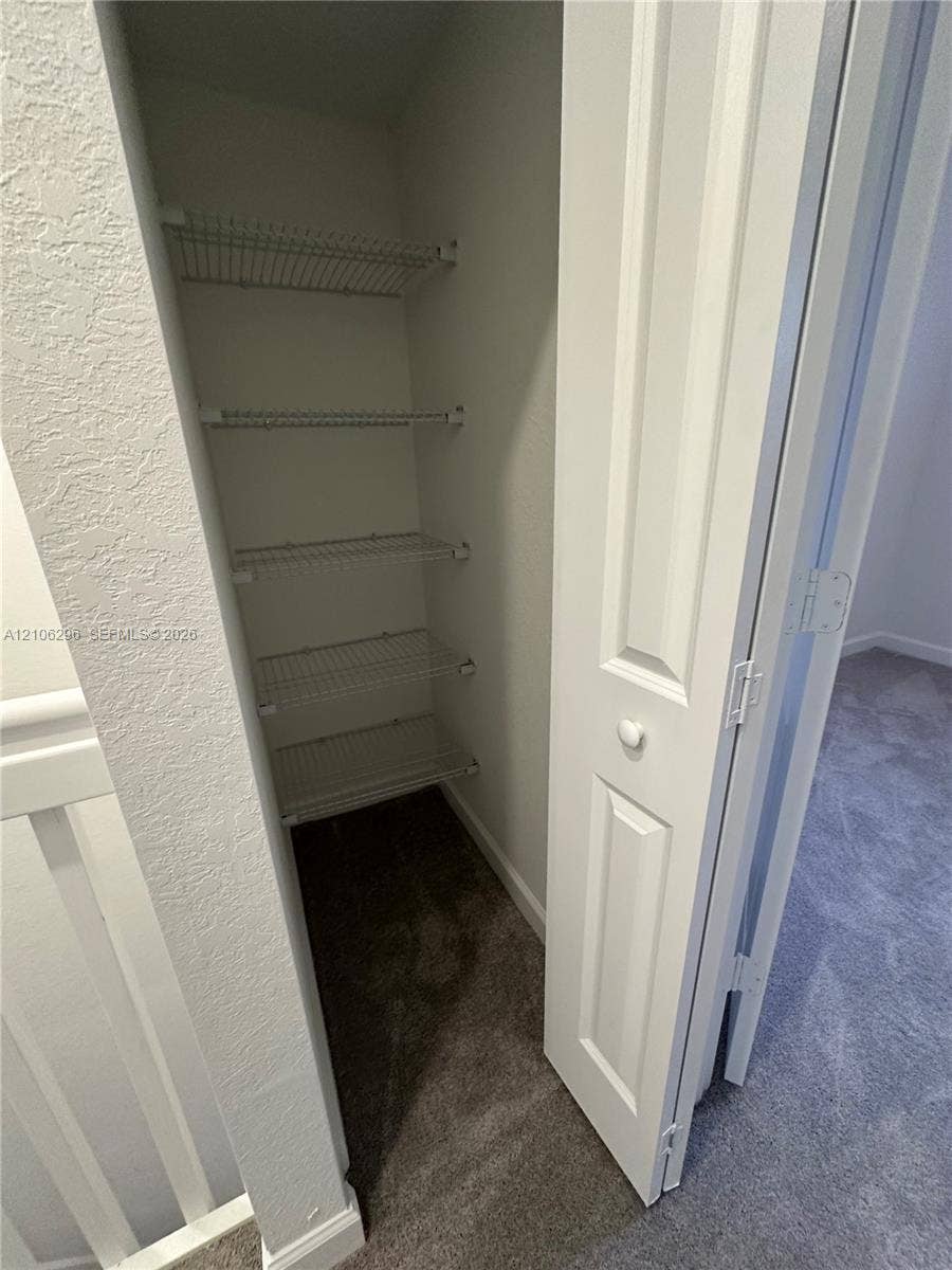 12103 NW 24th Place, #12103, Miami, Miami, FL 33167 Storage closet featuring four white wire shelves and a hinged, paneled interior door
