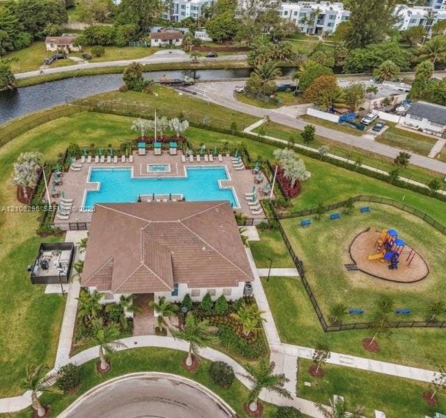 12103 NW 24th Place, #12103, Miami, Miami, FL 33167 Community clubhouse featuring a swimming pool, integrated spa, fenced playground, and professional landscaping
