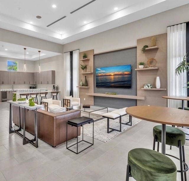 12103 NW 24th Place, #12103, Miami, Miami, FL 33167 Open concept area featuring high ceilings with recessed lighting, tile flooring, and custom wood-paneled media wall with built-in shelving