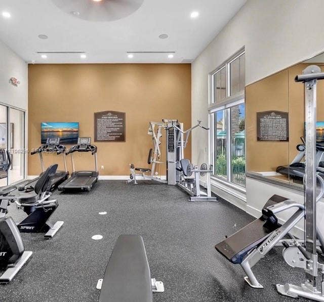 12103 NW 24th Place, #12103, Miami, Miami, FL 33167 Fitness center featuring high ceilings, recessed lighting, expansive mirrored wall, rubberized flooring, and floor-to-ceiling windows