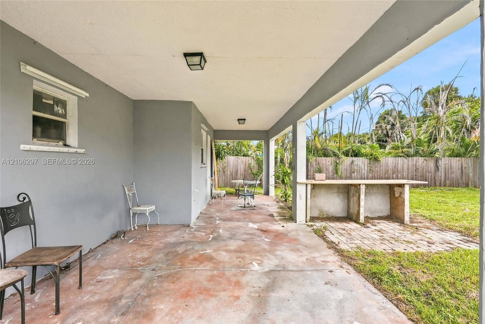 4810 Lakewood Park Drive, Fort Pierce, FL 34951 Covered patio featuring a concrete floor, built-in outdoor counter, and flush-mount lighting, overlooking a fenced backyard