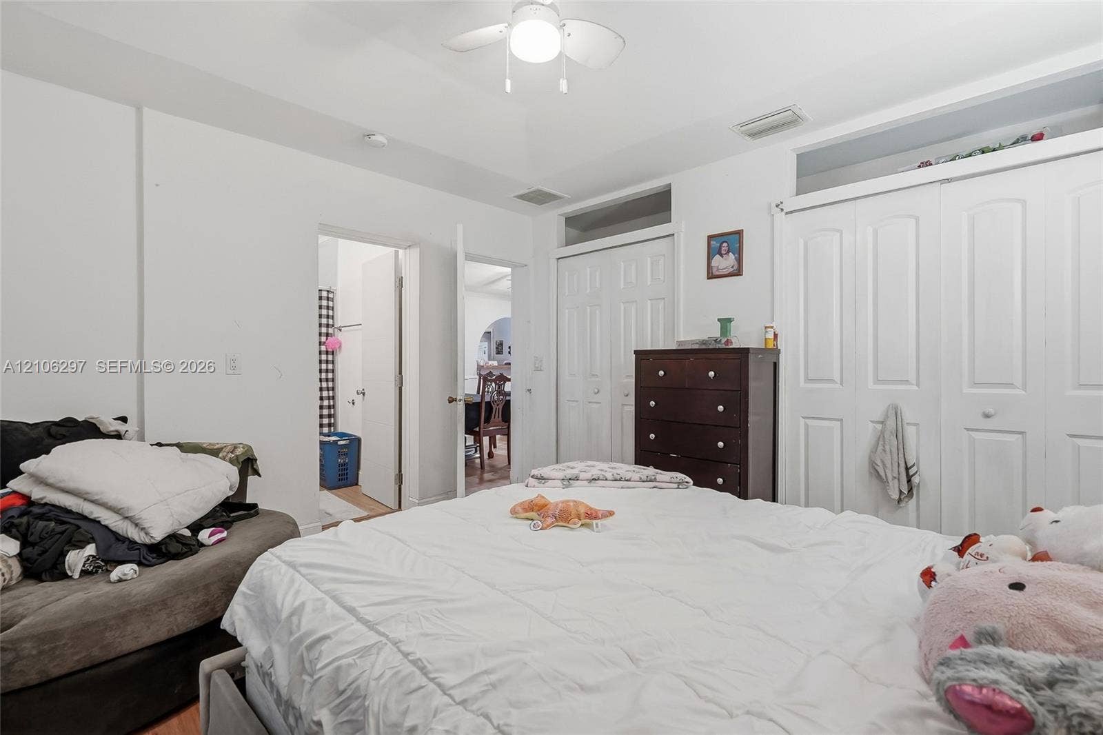 4810 Lakewood Park Drive, Fort Pierce, FL 34951 Tray ceiling featuring a central ceiling fan and white paneled closet doors with transom windows