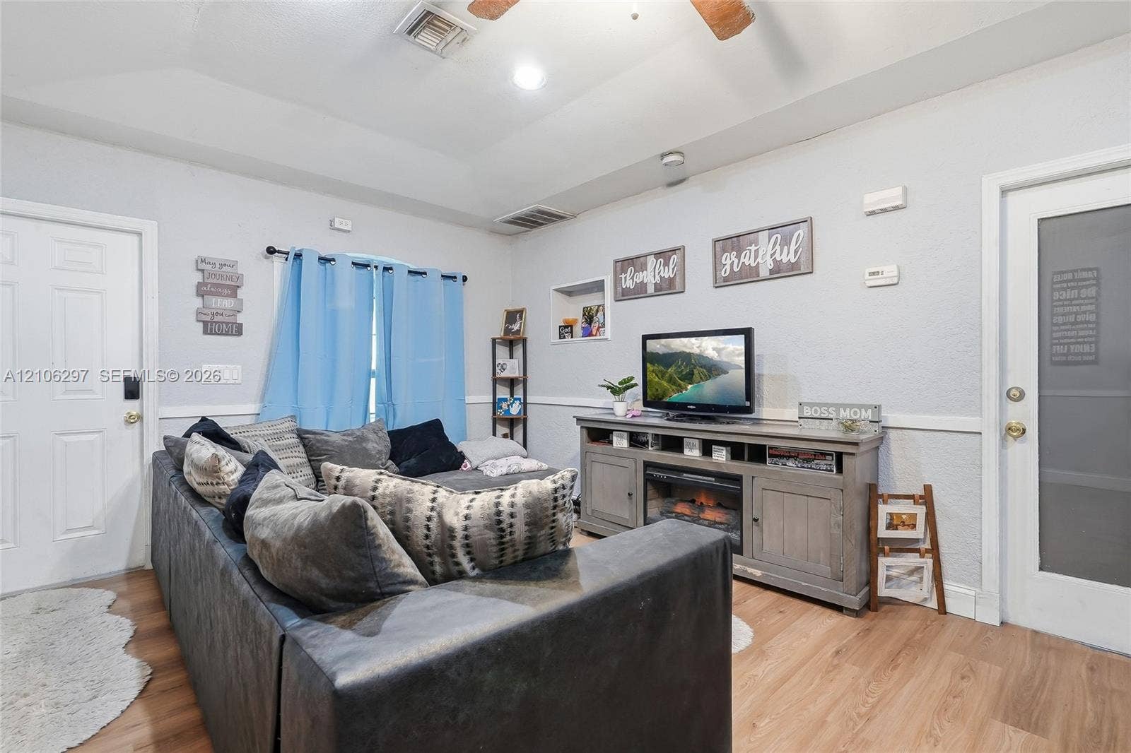 4810 Lakewood Park Drive, Fort Pierce, FL 34951 Living area featuring a tray ceiling, recessed lighting, wood-finish flooring, built-in wall niche, and chair rail molding