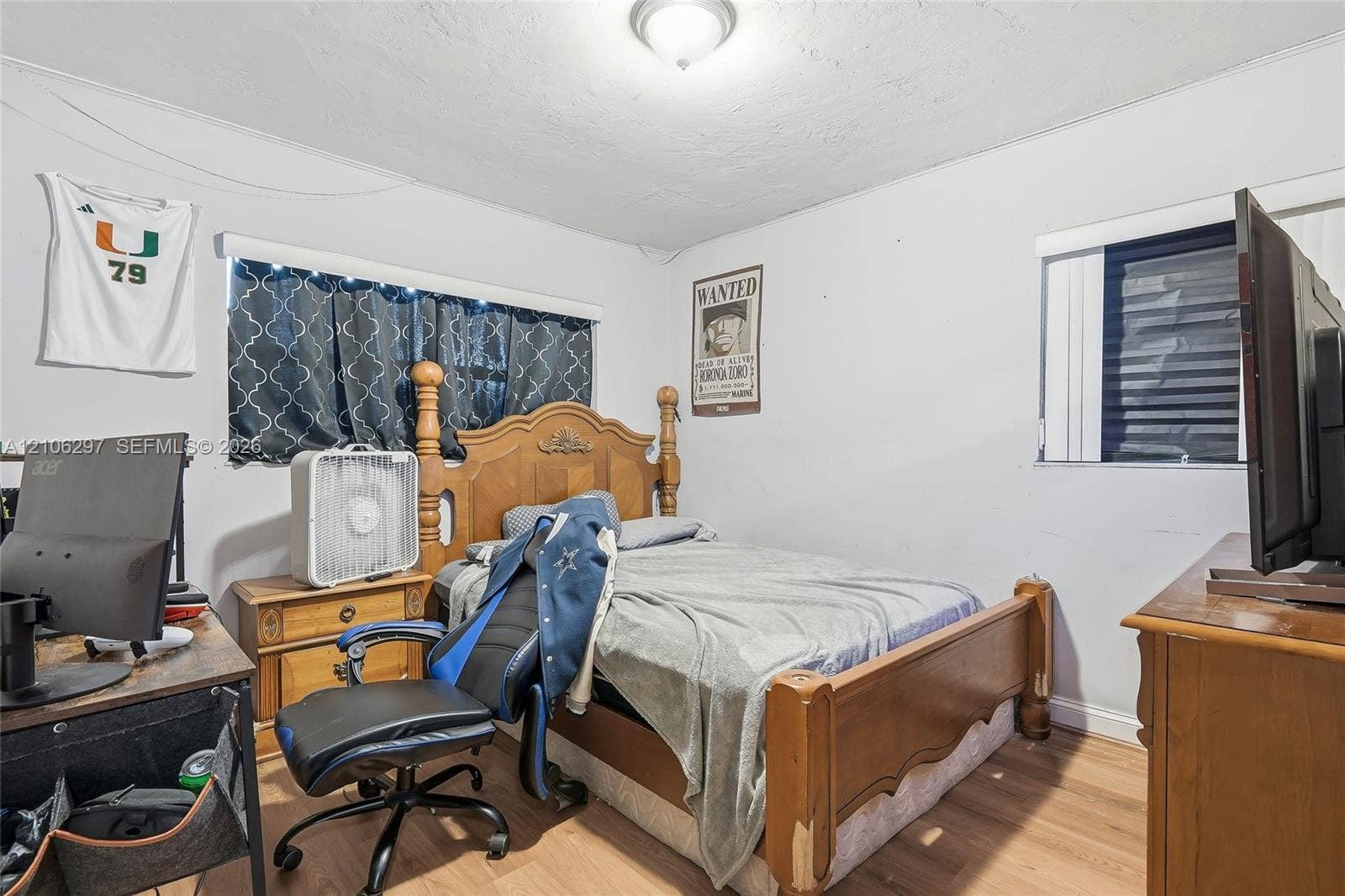 4810 Lakewood Park Drive, Fort Pierce, FL 34951 Bedroom featuring wood-finish flooring and two windows with horizontal blinds