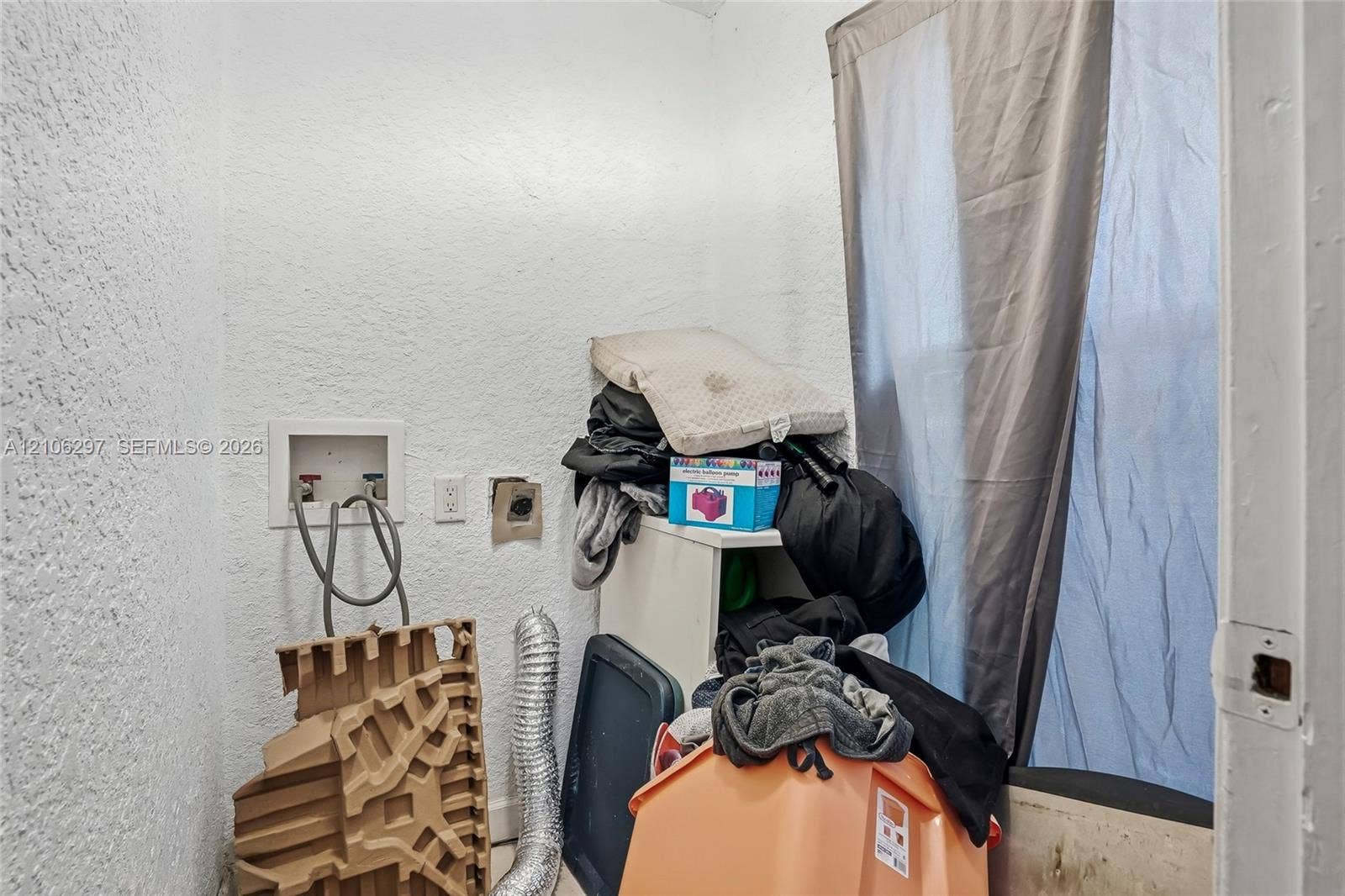 4810 Lakewood Park Drive, Fort Pierce, FL 34951 Utility area featuring textured walls, a dedicated water hookup box with control valves, and an integrated dryer exhaust vent