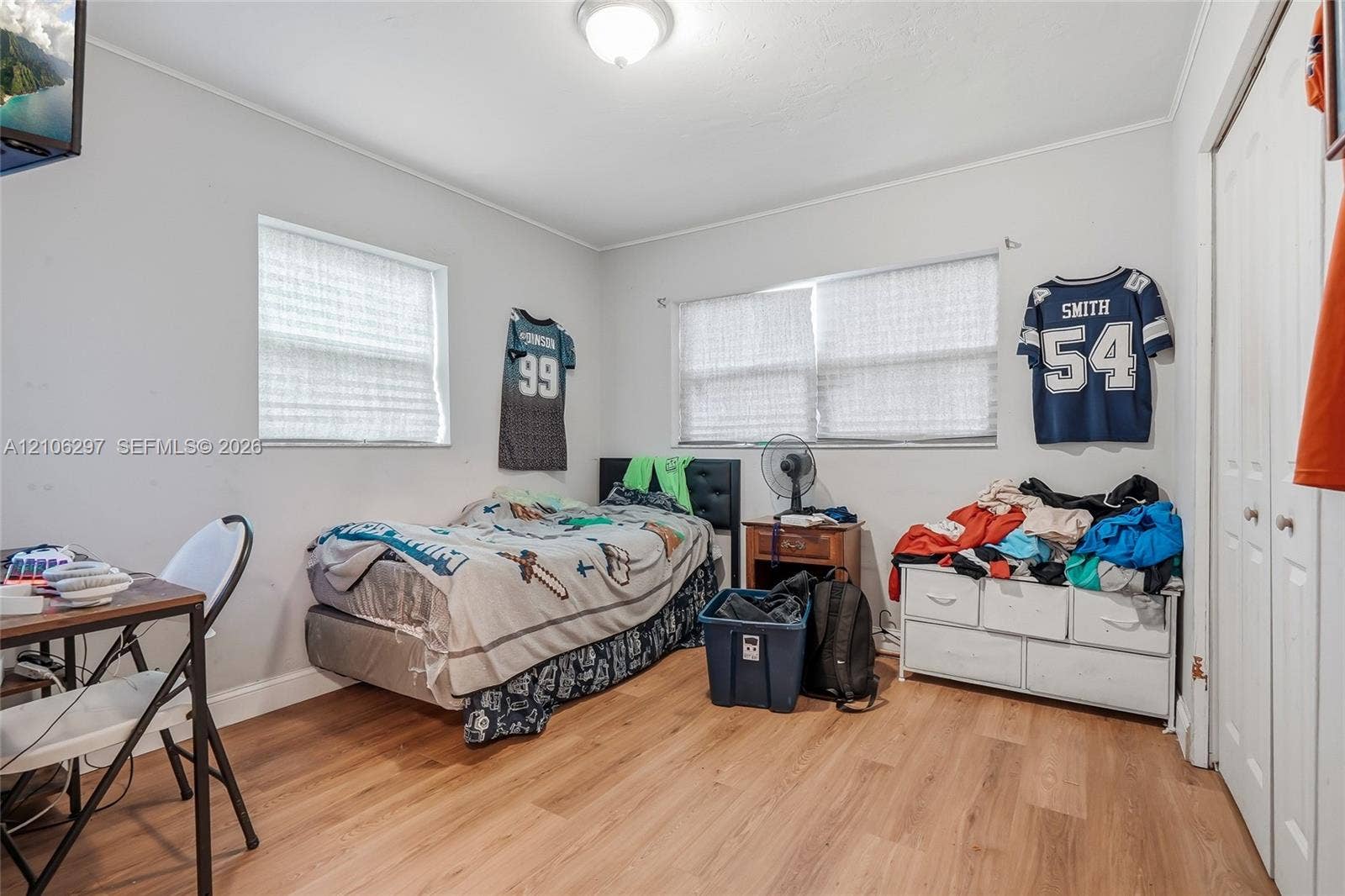 4810 Lakewood Park Drive, Fort Pierce, FL 34951 Neutral-toned interior room featuring wood-finish flooring, dual windows with blinds, and double-door closet storage