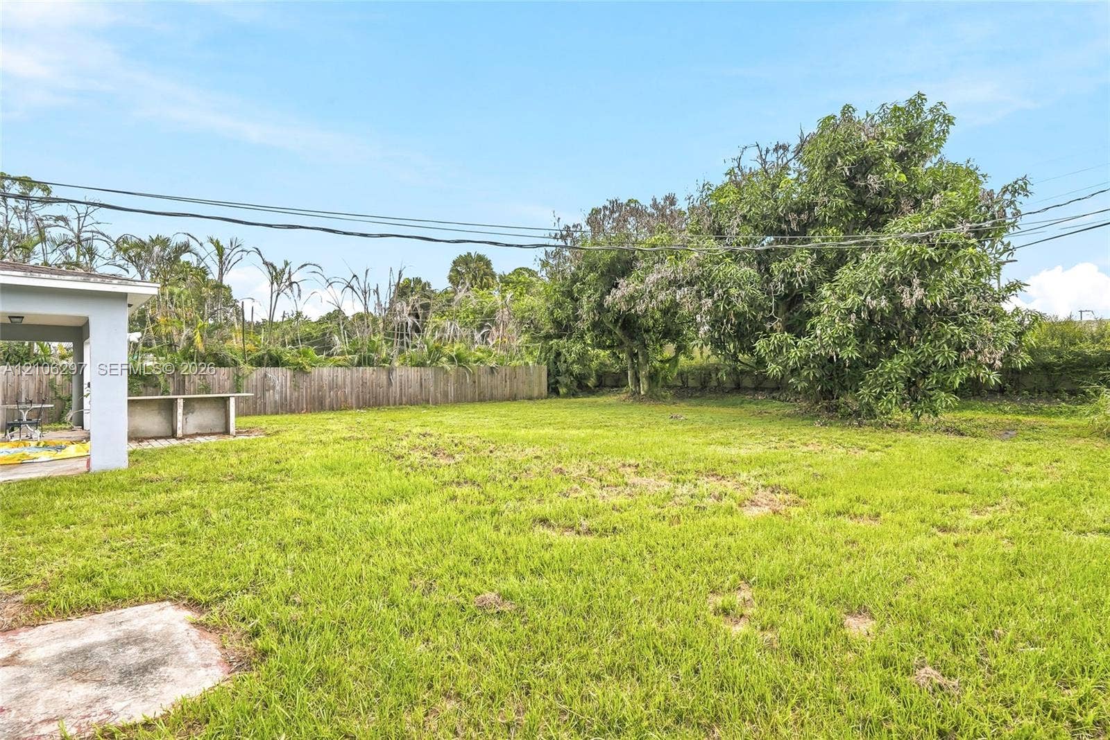 4810 Lakewood Park Drive, Fort Pierce, FL 34951 Spacious backyard featuring a concrete patio, built-in outdoor counter, wood fencing, and mature trees