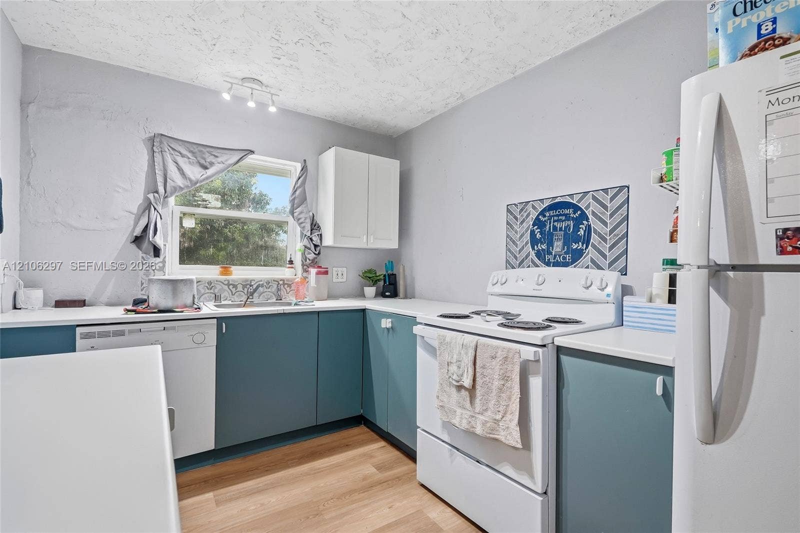 4810 Lakewood Park Drive, Fort Pierce, FL 34951 Kitchen featuring matte blue cabinetry, white countertops, wood-finish flooring, a stainless steel sink, and ceiling-mounted track lighting