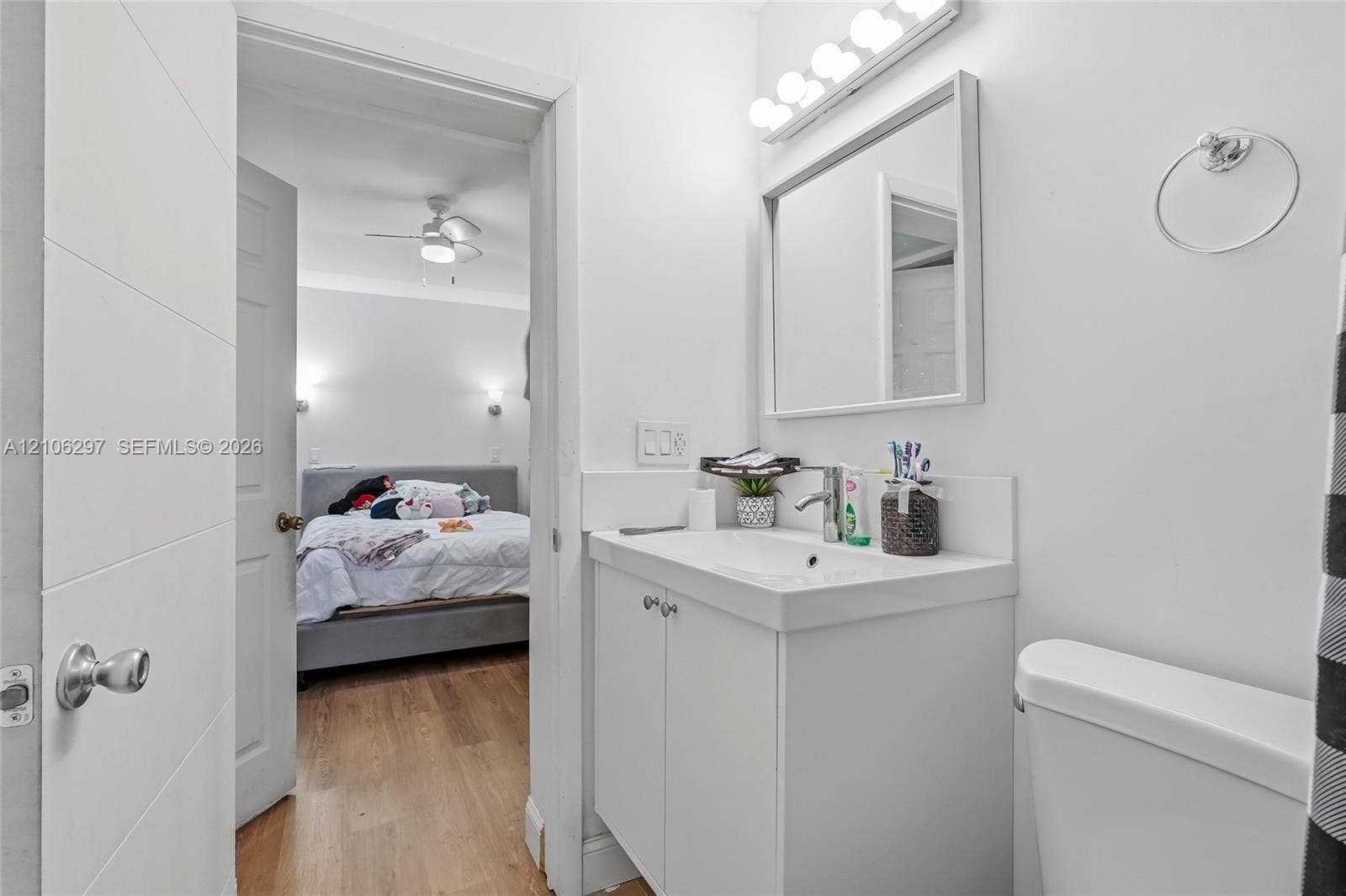 4810 Lakewood Park Drive, Fort Pierce, FL 34951 Bathroom featuring a white vanity cabinet, integrated sink, wall-mounted mirror, and multi-bulb light fixture