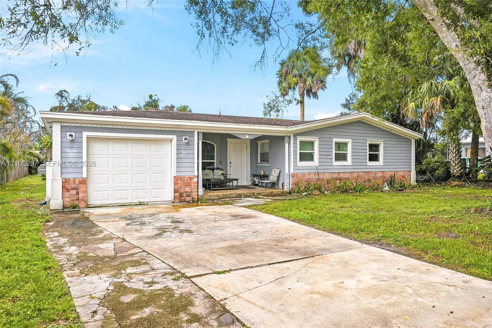 4810 Lakewood Park Drive, Fort Pierce, FL 34951 Single-story residence featuring horizontal lap siding, a lower-level stone facade, a one-car garage, and a covered front entryway