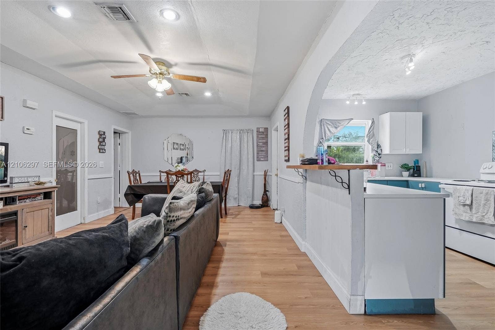 4810 Lakewood Park Drive, Fort Pierce, FL 34951 Open-concept interior featuring wood-finish flooring, a kitchen breakfast bar with decorative corbels, recessed lighting, a ceiling fan, and a wide arched entryway
