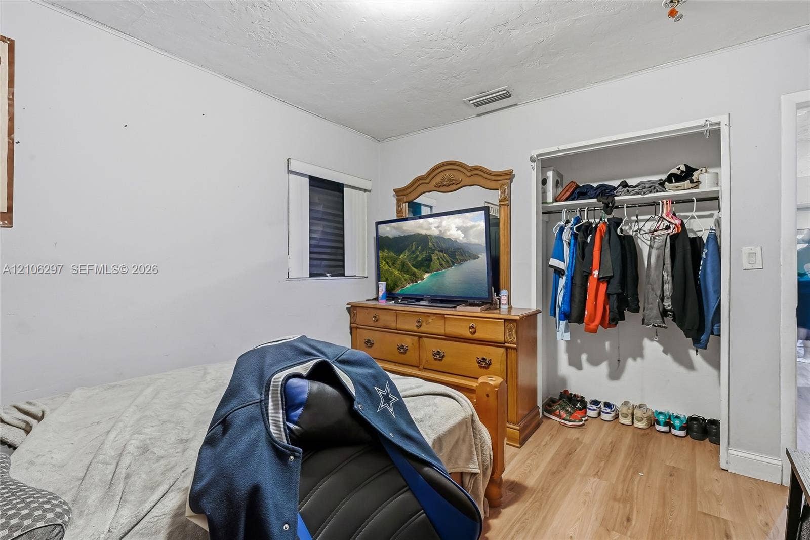 4810 Lakewood Park Drive, Fort Pierce, FL 34951 Room featuring wood-finish flooring, a window with horizontal blinds, and a built-in closet with overhead shelving and hanging rod