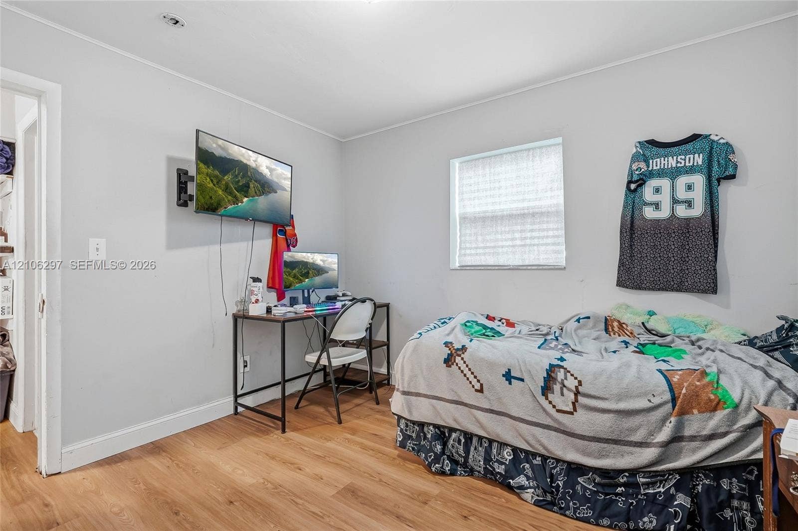 4810 Lakewood Park Drive, Fort Pierce, FL 34951 Interior room featuring light-toned neutral wall paint, wood-finish flooring, and a single window with a privacy blind