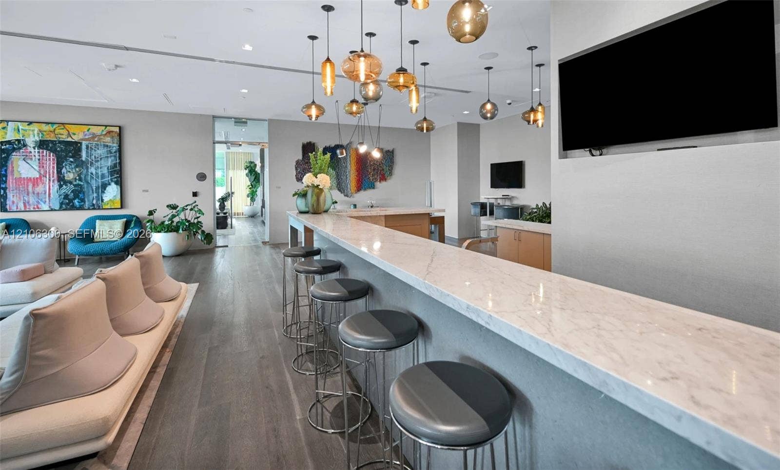 480 NE 31st Street, #1005, Miami, Miami, FL 33137 Stone-surfaced bar counter with integrated recessed display wall, wood-finish flooring, and multi-pendant lighting