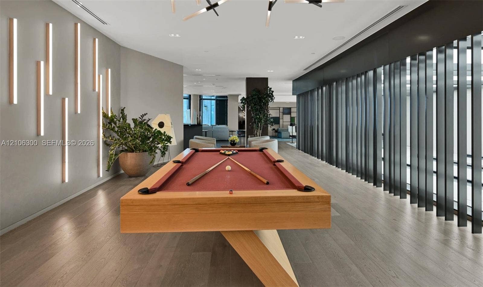 480 NE 31st Street, #1005, Miami, Miami, FL 33137 Open-concept recreational space featuring wood-finish flooring, vertical wall-mounted accent lighting, and a series of floor-to-ceiling structural fins