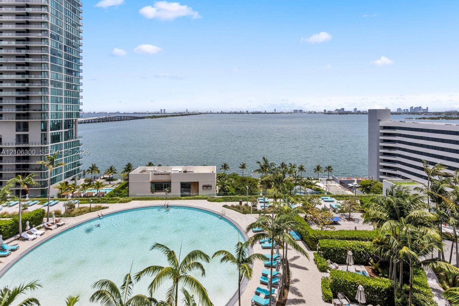 480 NE 31st Street, #1005, Miami, Miami, FL 33137 Curved swimming pool with paved decking, landscaped perimeter, and expansive water backdrop