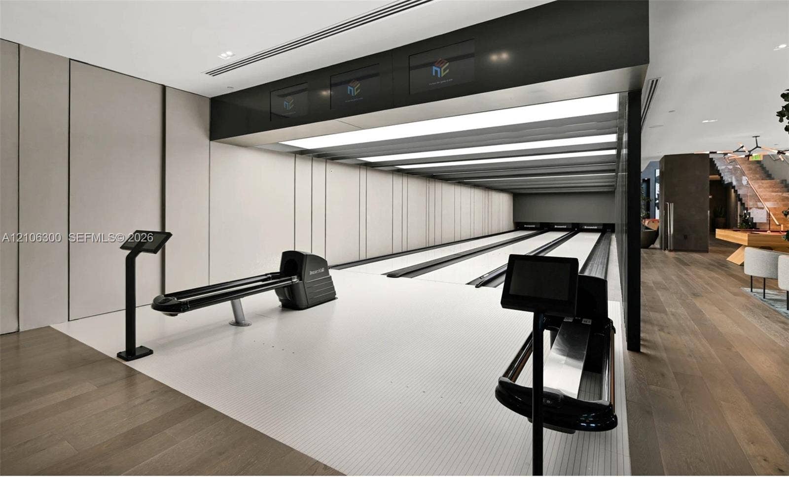 480 NE 31st Street, #1005, Miami, Miami, FL 33137 Private three-lane bowling alley featuring recessed linear lighting, integrated electronic scoring consoles, wood-finish flooring, and minimalist paneled walls