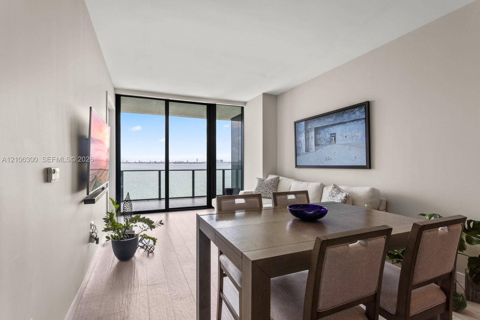 480 NE 31st Street, #1005, Miami, Miami, FL 33137 Neutral wall tones, wood-finish flooring, floor-to-ceiling glass sliding doors, and a private balcony featuring a metal railing