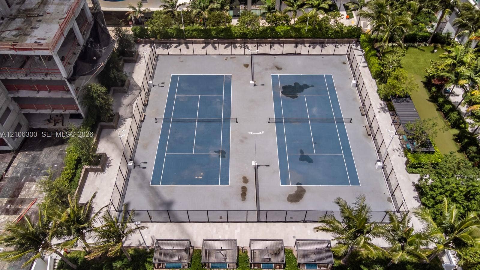 480 NE 31st Street, #1005, Miami, Miami, FL 33137 Dual-court tennis facility featuring perimeter chain-link fencing, high-mast lighting, and surrounding palm tree landscaping