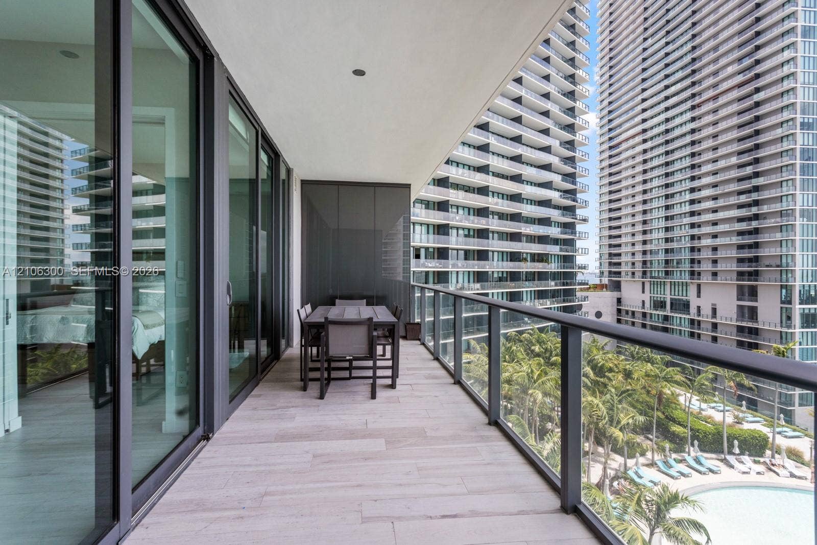 480 NE 31st Street, #1005, Miami, Miami, FL 33137 Covered balcony featuring wood-finish tile flooring, glass railings, and expansive sliding glass doors