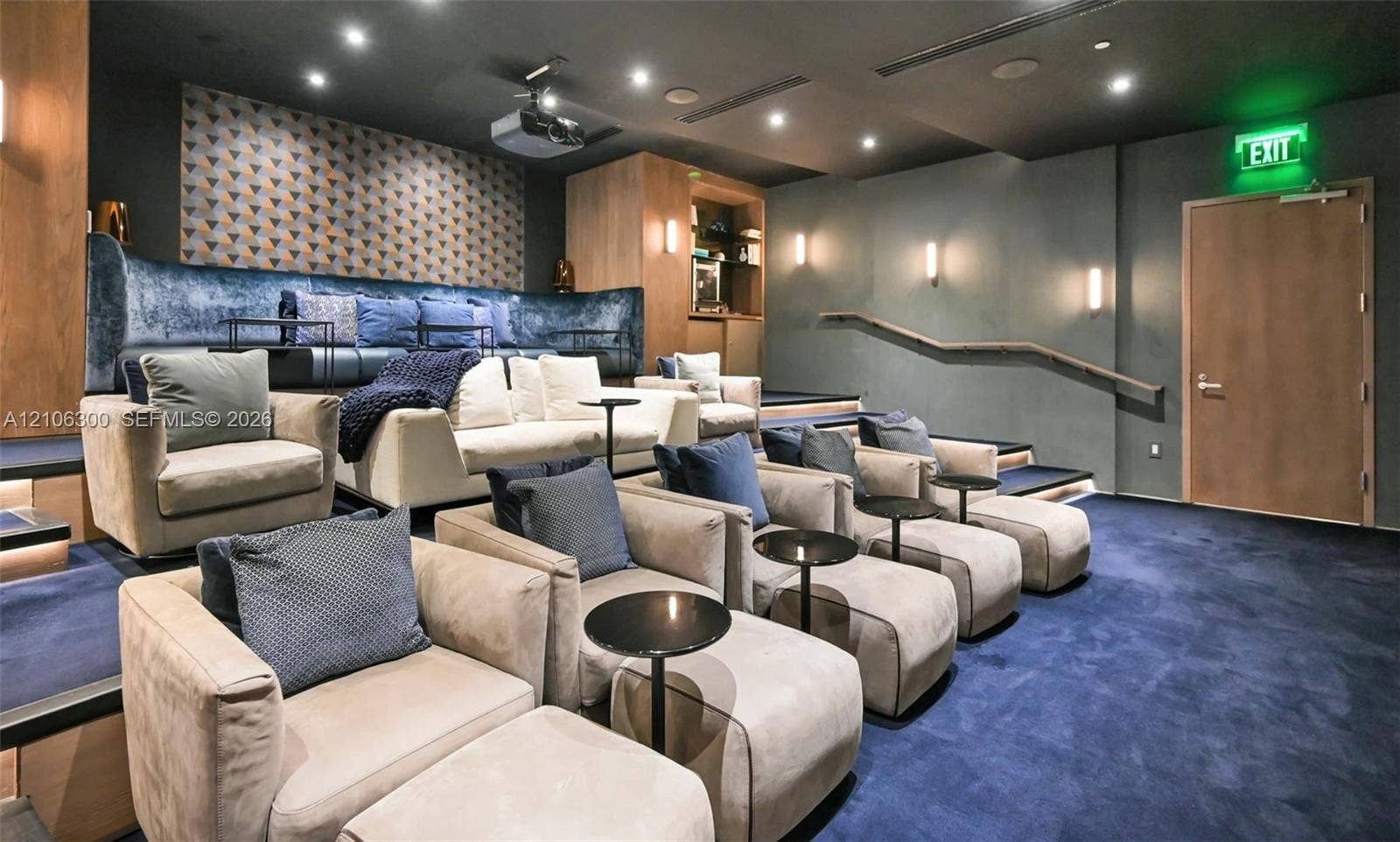 480 NE 31st Street, #1005, Miami, Miami, FL 33137 Tiered seating platform with carpeted finish, recessed ceiling lighting, wall-mounted sconces, wood-paneled wall accents, and built-in projection system