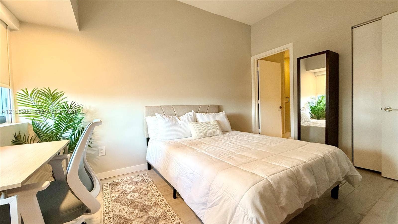 480 NE 31st Street, #1005, Miami, Miami, FL 33137 Bedroom featuring neutral-toned walls, wood-finish flooring, and a built-in closet with sliding doors