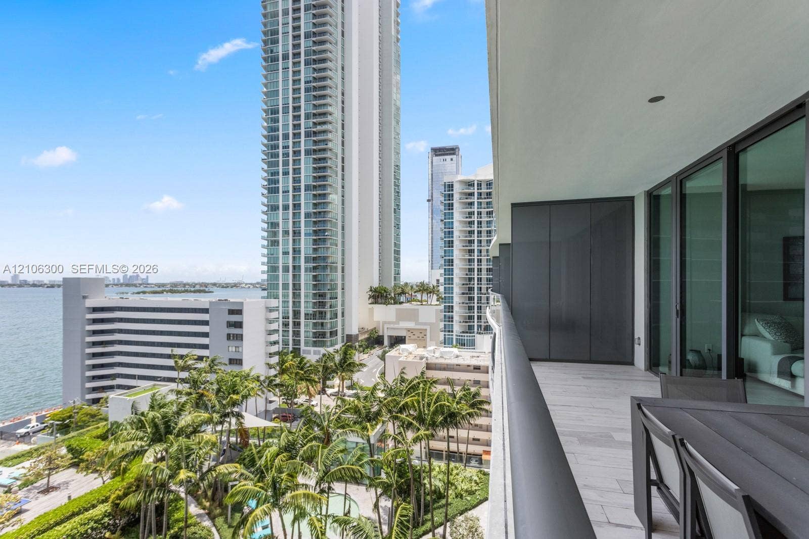 480 NE 31st Street, #1005, Miami, Miami, FL 33137 Covered balcony with stone-finish flooring, glass railing, and floor-to-ceiling glass sliding door panels
