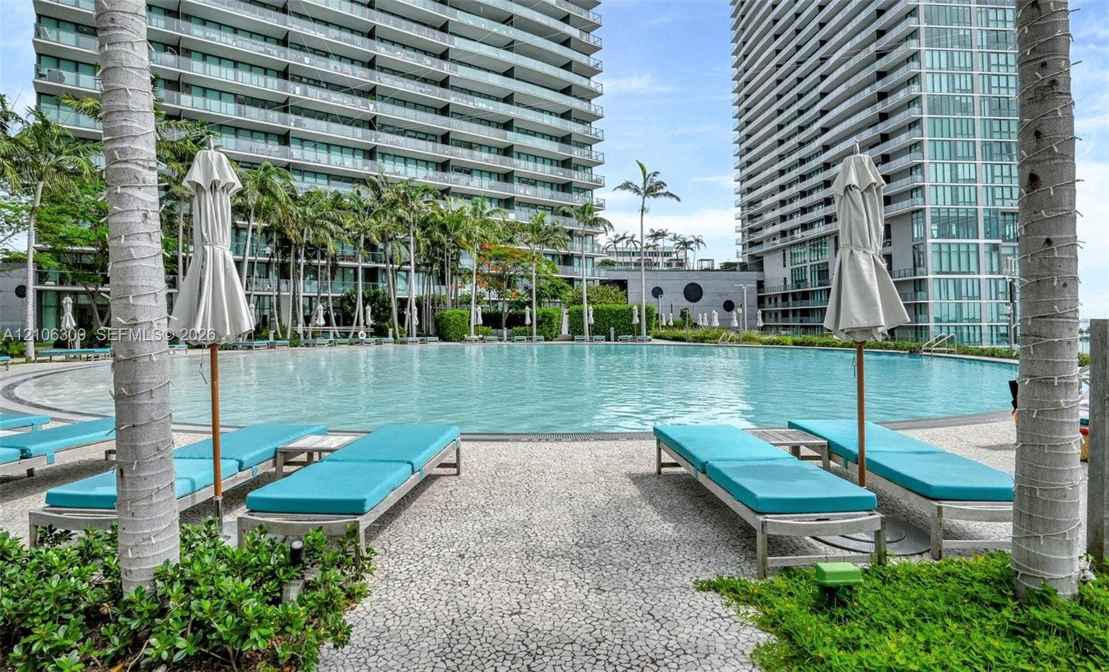 480 NE 31st Street, #1005, Miami, Miami, FL 33137 Resort-style circular swimming pool featuring stone paver decking, surrounding palm trees, and manicured landscaping