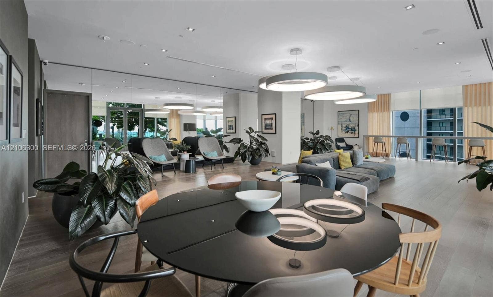 480 NE 31st Street, #1005, Miami, Miami, FL 33137 Open-concept interior featuring wood-finish flooring, recessed lighting, expansive floor-to-ceiling windows, and large circular pendant light fixtures