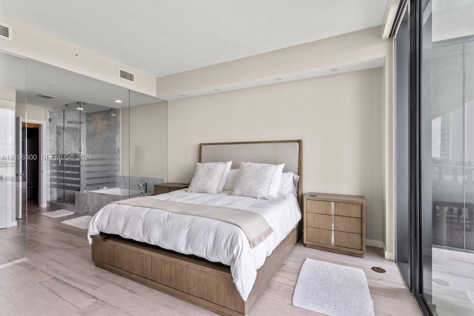 480 NE 31st Street, #1005, Miami, Miami, FL 33137 Neutral-toned interior featuring wood-finish flooring, full-height glass partitions, a glass-enclosed shower, and expansive sliding glass doors