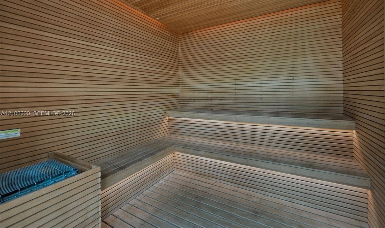 480 NE 31st Street, #1005, Miami, Miami, FL 33137 Sauna featuring horizontal wood-slat wall paneling, multi-level tiered wood benches, integrated recessed lighting, and a metal heating unit enclosure