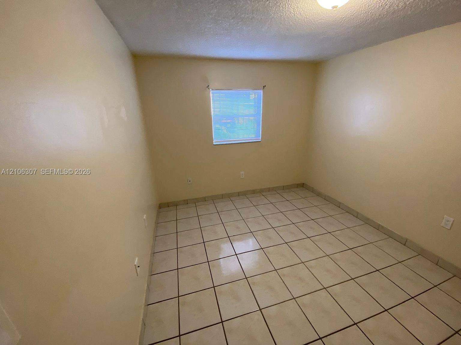 Interior room featuring neutral-toned wall paint and ceramic tile flooring