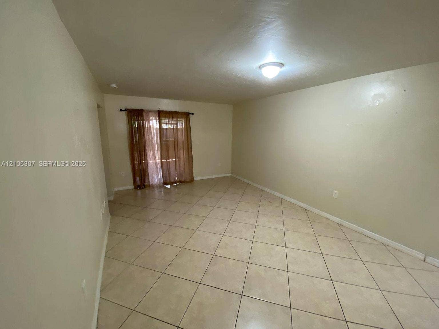 Interior space featuring diagonal ceramic tile flooring, neutral wall tones, and glass sliding doors