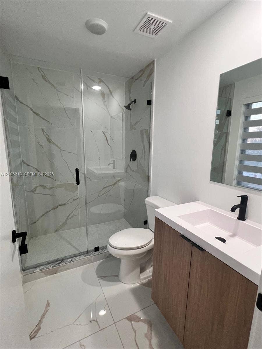 14508 SW 260th Street, #14508, Homestead, Homestead, FL 33032 Walk-in shower featuring large-format tile surround, frameless glass enclosure, wood-finish vanity with rectangular basin, white quartz countertop, and matte black fixtures