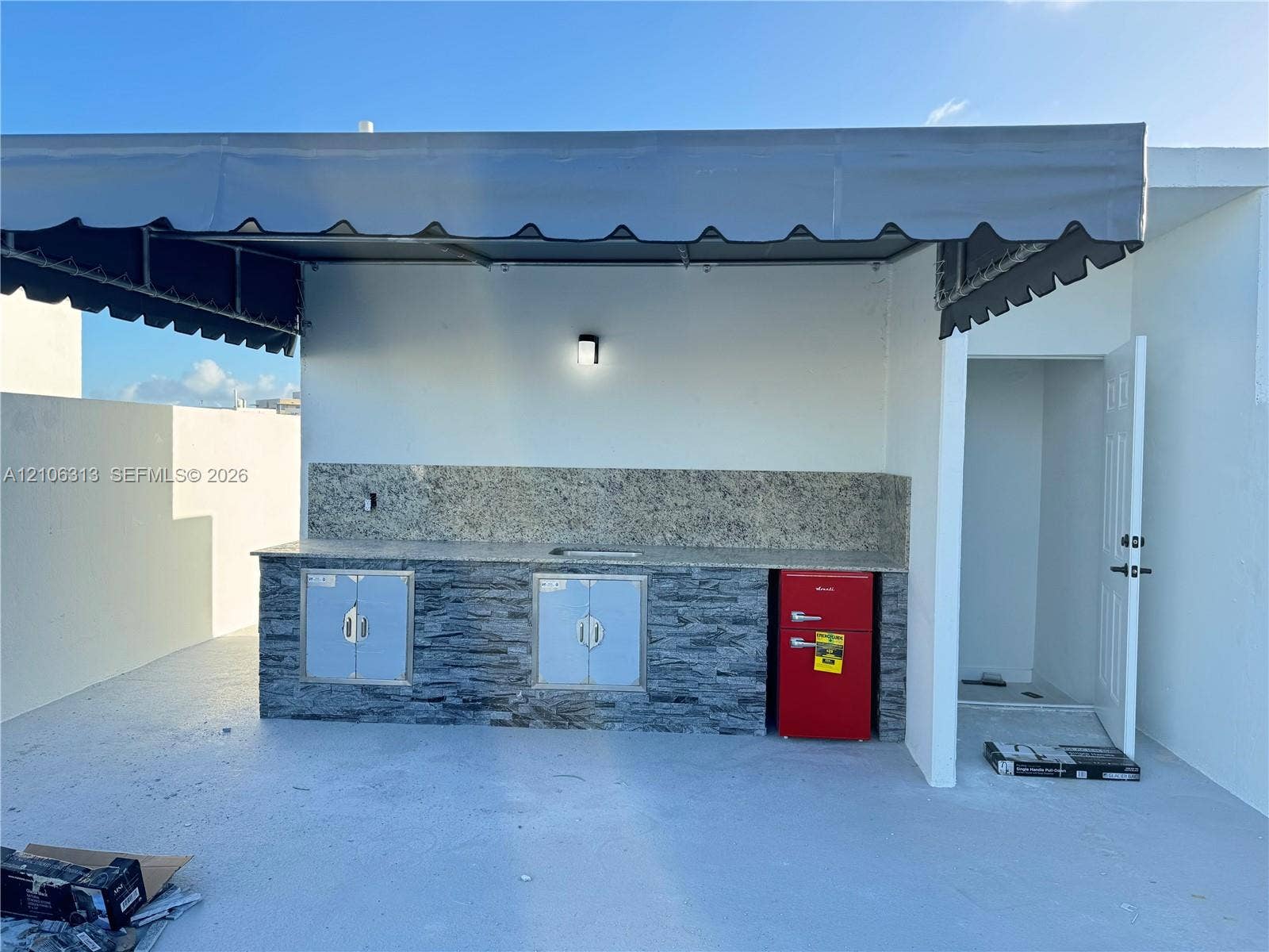 14508 SW 260th Street, #14508, Homestead, Homestead, FL 33032 Outdoor kitchenette featuring stone-veneer base cabinetry, stone-slab countertop, built-in stainless steel cabinet doors, and a protective overhead canopy