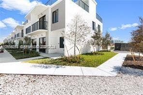 14508 SW 260th Street, #14508, Homestead, Homestead, FL 33032 Modern multi-story exterior featuring white stucco finishes, black-framed balcony railings, flat roofing, and a rooftop terrace