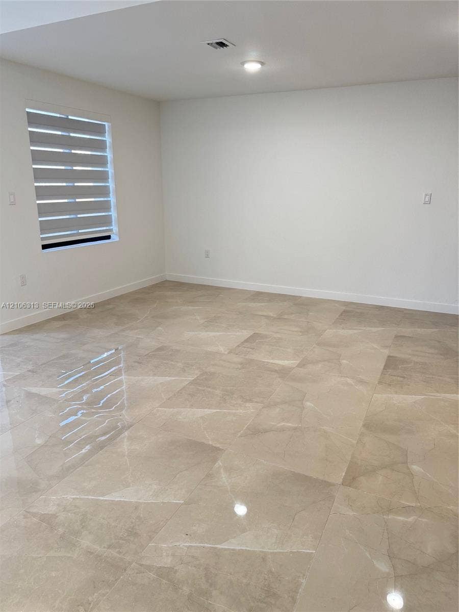 14508 SW 260th Street, #14508, Homestead, Homestead, FL 33032 Neutral interior space featuring polished tile flooring, crisp white walls, and horizontal dual-layer window treatments
