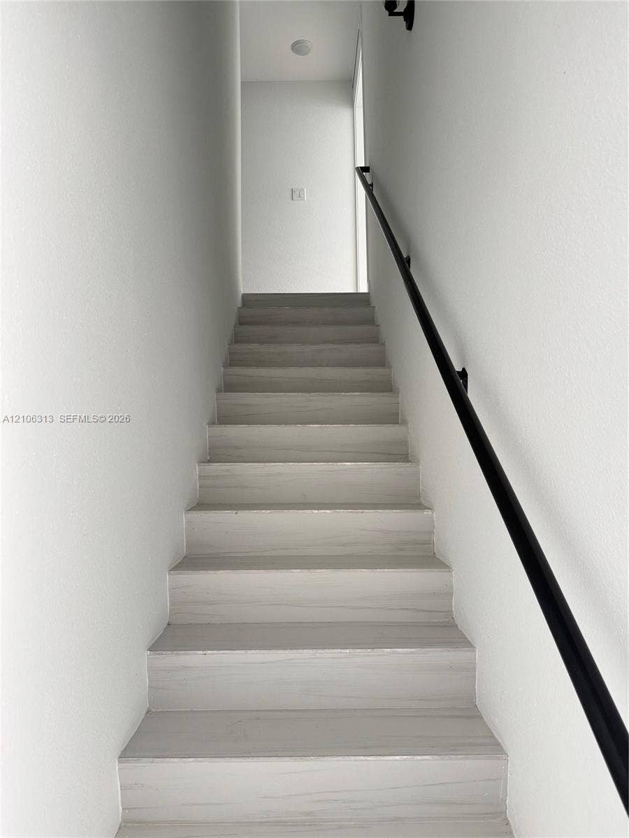 14508 SW 260th Street, #14508, Homestead, Homestead, FL 33032 Staircase featuring wood-finish treads and a matte black wall-mounted handrail