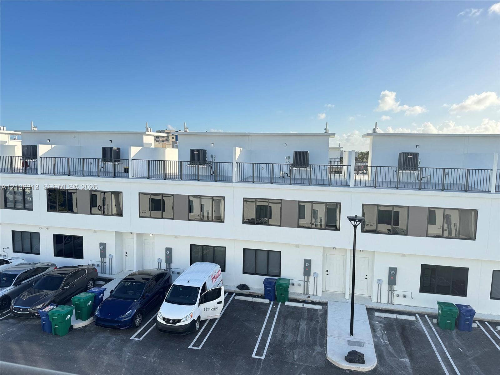14508 SW 260th Street, #14508, Homestead, Homestead, FL 33032 Contemporary multi-story exterior featuring a crisp white finish, flat roofline, integrated rooftop balconies with metal railings, and oversized rectangular windows