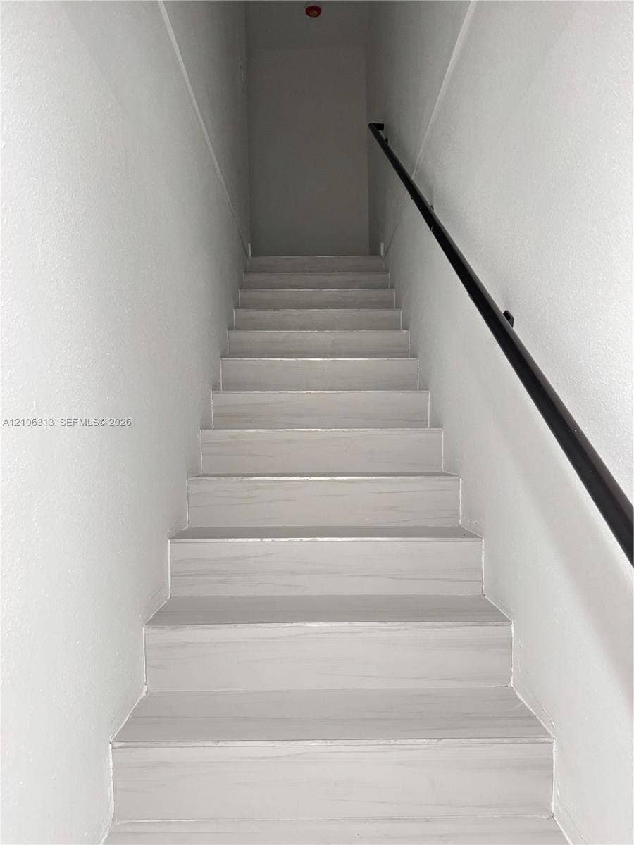 14508 SW 260th Street, #14508, Homestead, Homestead, FL 33032 Staircase featuring light-toned wood-finish treads and a matte black wall-mounted handrail