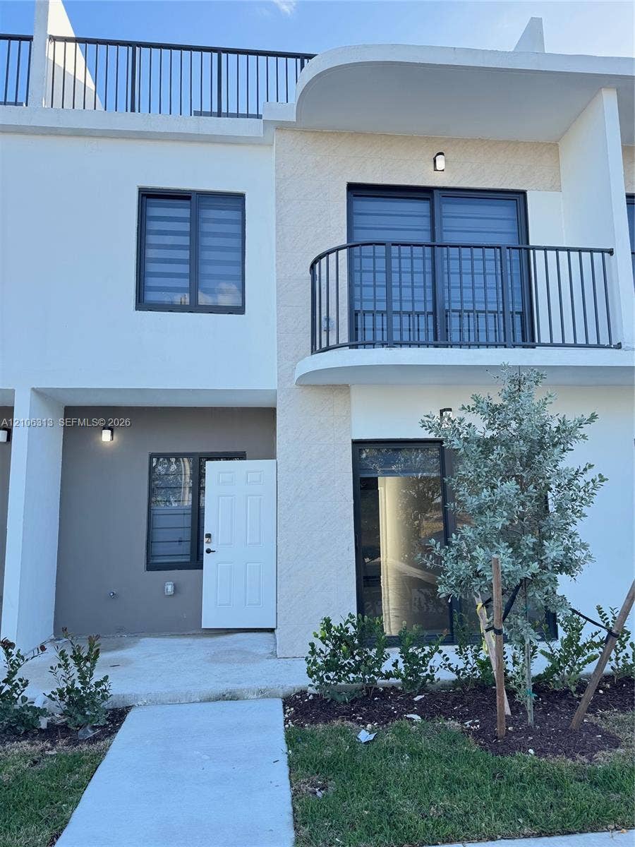 14508 SW 260th Street, #14508, Homestead, Homestead, FL 33032 Contemporary multi-story exterior featuring a private second-level balcony with metal railing, rooftop terrace, sliding glass doors, and integrated wall-mounted lighting