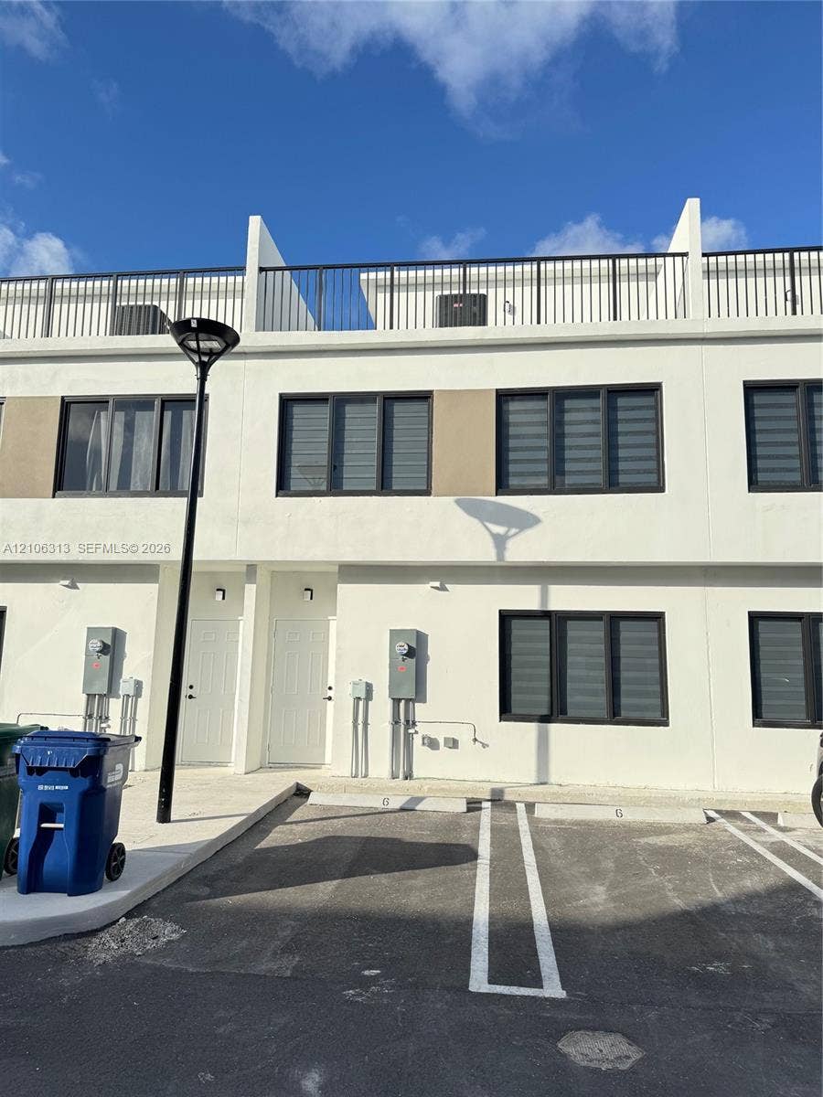 14508 SW 260th Street, #14508, Homestead, Homestead, FL 33032 Modern multi-story exterior featuring smooth stucco facade, black-framed windows, and rooftop terrace with metal railing