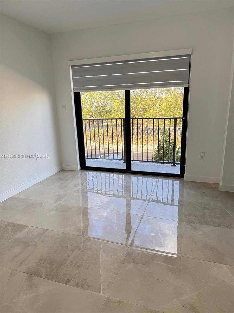 14508 SW 260th Street, #14508, Homestead, Homestead, FL 33032 Large-format tile flooring, sliding glass door with black frame, retractable window shade, and exterior balcony featuring metal railing